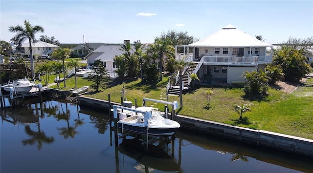 view of dock with a water view, boat lift, stairs, and a yard