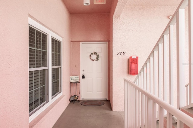 doorway to property featuring stucco siding