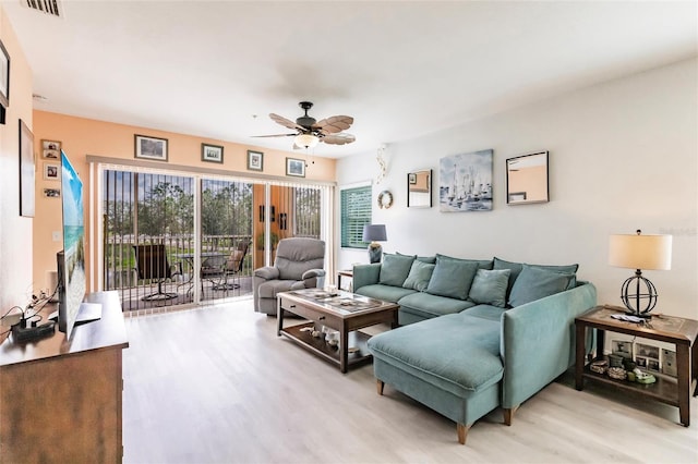 living area with ceiling fan, visible vents, and wood finished floors