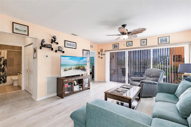 living room with visible vents, ceiling fan, light wood-style flooring, and baseboards