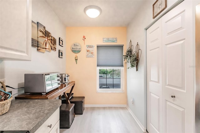 interior space featuring light wood finished floors and baseboards