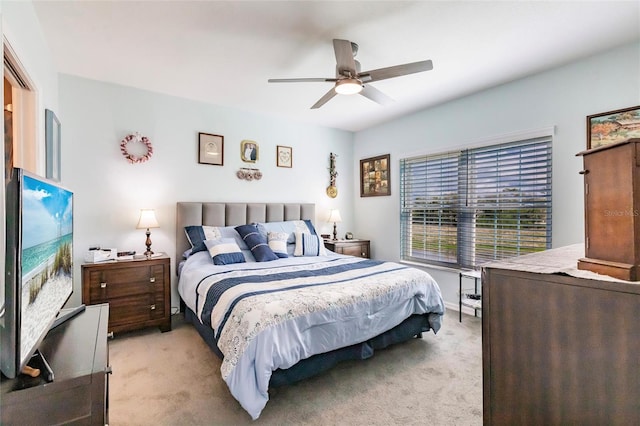 bedroom with light carpet and a ceiling fan