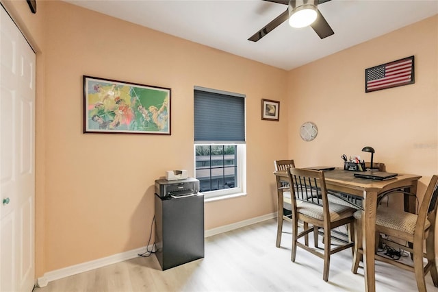 dining space featuring light wood-type flooring, baseboards, and a ceiling fan