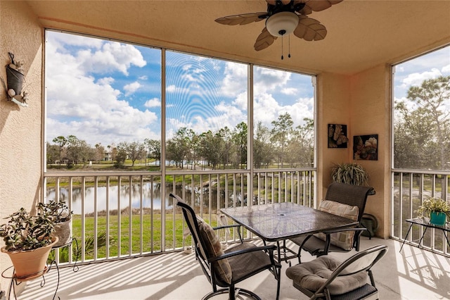 sunroom / solarium with a ceiling fan, a healthy amount of sunlight, and a water view