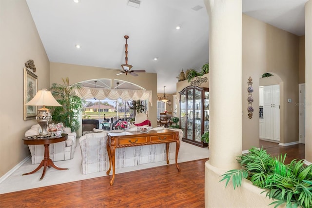 foyer with arched walkways, visible vents, a ceiling fan, wood finished floors, and high vaulted ceiling