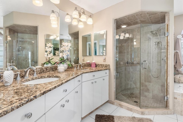 bathroom with double vanity, a stall shower, tile patterned flooring, and a sink