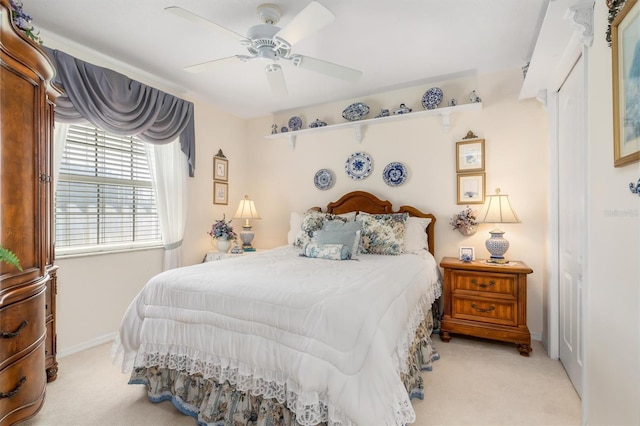 bedroom with light carpet, a ceiling fan, and baseboards