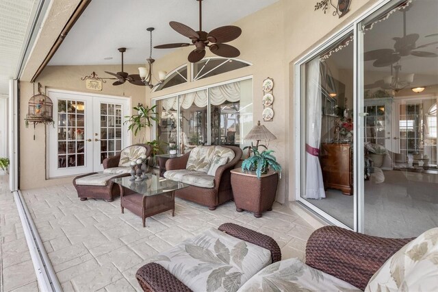 sunroom / solarium featuring ceiling fan, french doors, plenty of natural light, and lofted ceiling