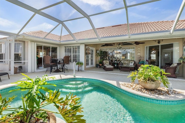 outdoor pool featuring a lanai, ceiling fan, and a patio