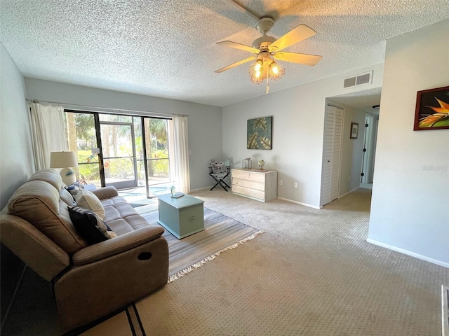 carpeted living area featuring baseboards, a textured ceiling, visible vents, and a ceiling fan