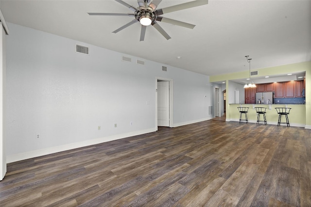 unfurnished living room with visible vents, baseboards, dark wood finished floors, and a ceiling fan