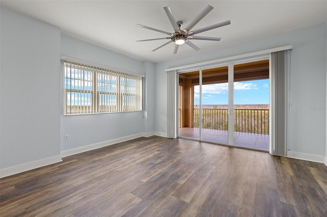 unfurnished room featuring baseboards, ceiling fan, and dark wood-style flooring