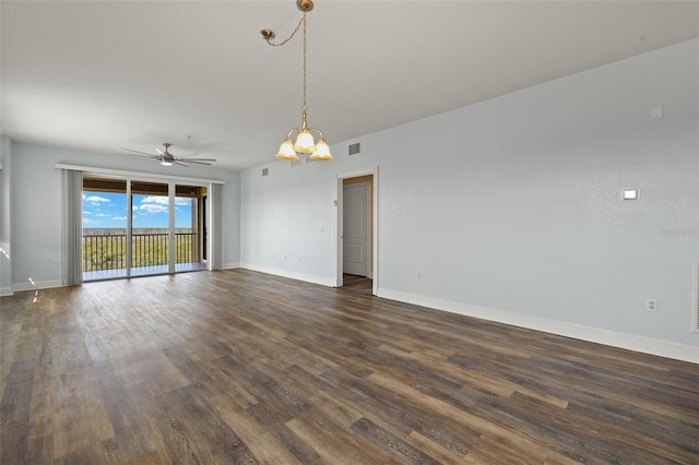 spare room featuring visible vents, baseboards, dark wood-type flooring, and ceiling fan with notable chandelier