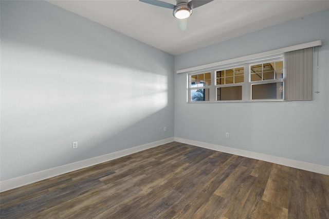 spare room featuring baseboards, dark wood-style floors, and a ceiling fan