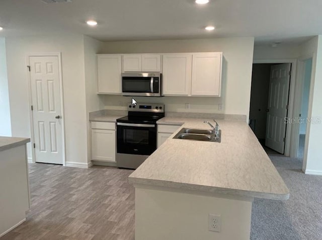 363 Underwood Trl, Palm Coast, FL 32164 - kitchen with a sink, appliances with stainless steel finishes, a peninsula, white cabinets, and light countertops