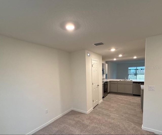 kitchen with gray cabinetry, a sink, visible vents, black electric range oven, and dishwasher