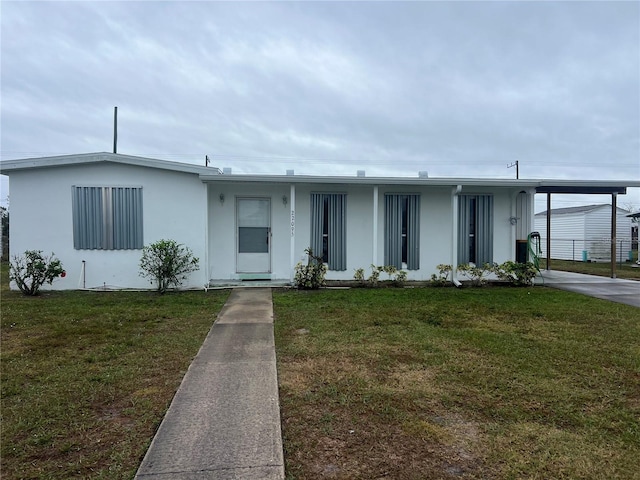 view of front facade featuring a carport, a front yard, and stucco siding