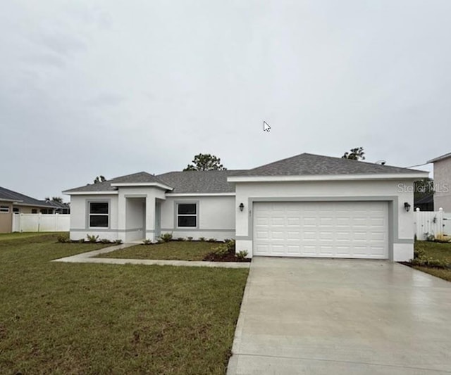 view of front of property with driveway, an attached garage, a front lawn, and stucco siding