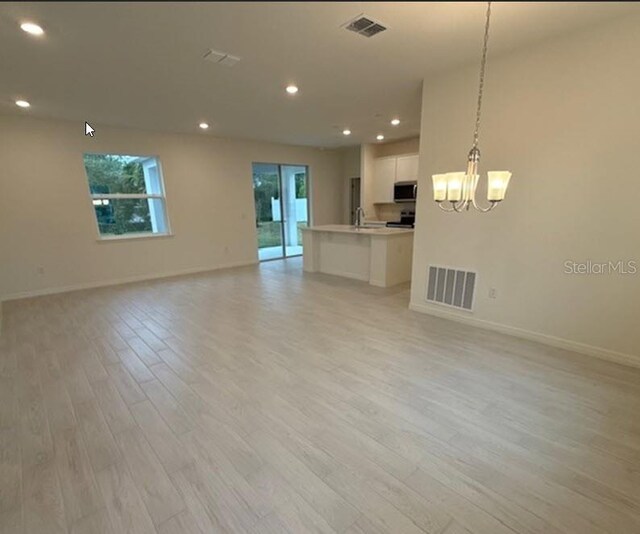 unfurnished living room with recessed lighting, visible vents, and light wood-style floors