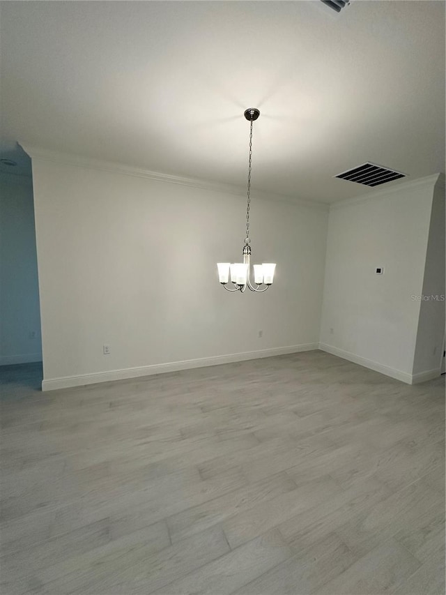 interior space featuring crown molding, a notable chandelier, light wood finished floors, visible vents, and baseboards