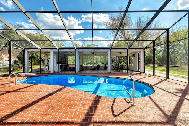 outdoor pool with a patio area, a lanai, and a ceiling fan