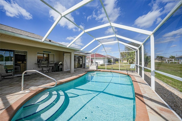 outdoor pool featuring glass enclosure, a patio, and a lawn