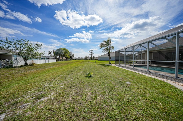 view of yard with a lanai, fence, and an outdoor pool