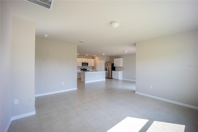 unfurnished living room with light tile patterned floors, visible vents, recessed lighting, and baseboards