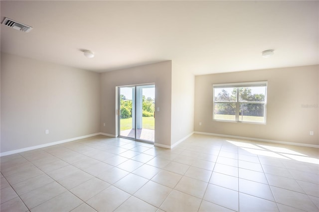 empty room featuring light tile patterned flooring, baseboards, and visible vents