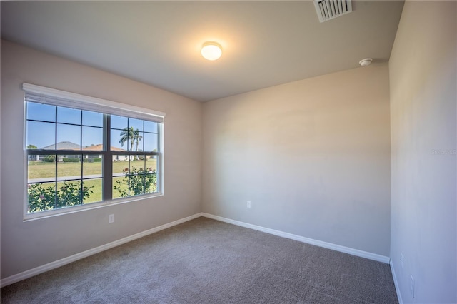 carpeted empty room featuring visible vents and baseboards