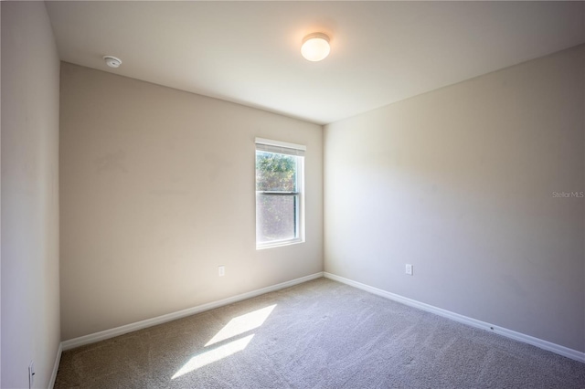 empty room featuring baseboards and carpet floors