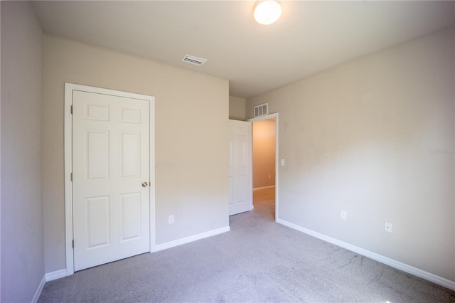 unfurnished bedroom featuring visible vents, baseboards, and carpet