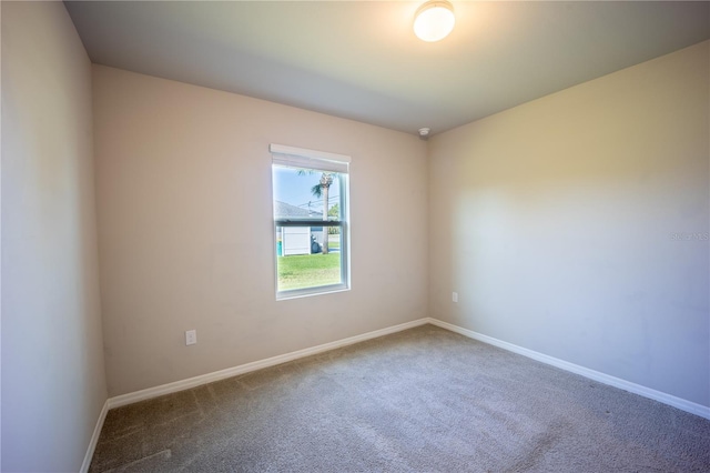 carpeted empty room featuring baseboards