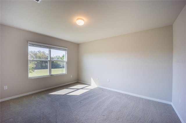 unfurnished room with carpet flooring and baseboards