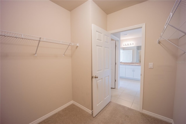 spacious closet with light tile patterned floors and light carpet