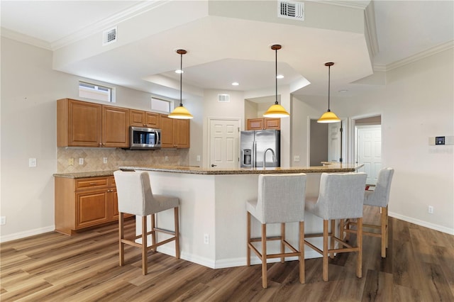 kitchen with hanging light fixtures, visible vents, and appliances with stainless steel finishes