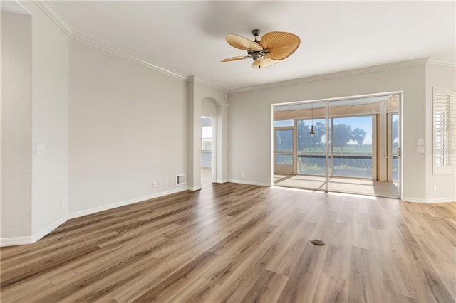 spare room featuring crown molding, wood finished floors, and baseboards