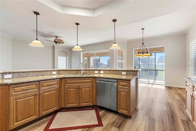 kitchen featuring a sink, light stone counters, brown cabinets, decorative light fixtures, and stainless steel dishwasher