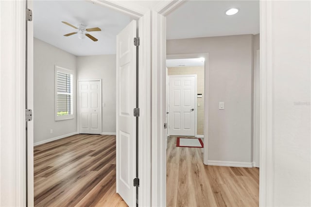 corridor with baseboards and light wood-type flooring