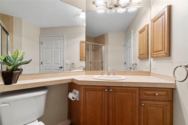 bathroom with a stall shower, vanity, and toilet