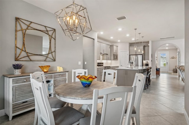 dining space featuring a notable chandelier and light tile patterned floors