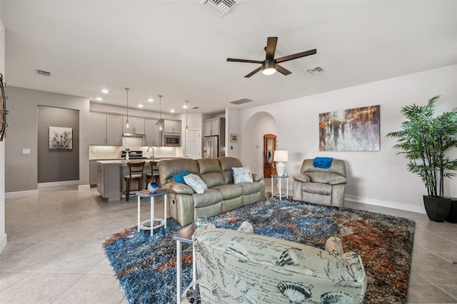 tiled living room with sink and ceiling fan