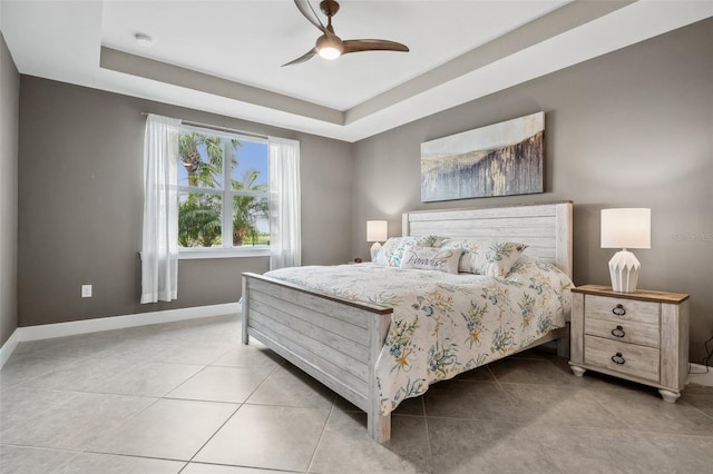 bedroom with a raised ceiling, ceiling fan, and light tile patterned floors