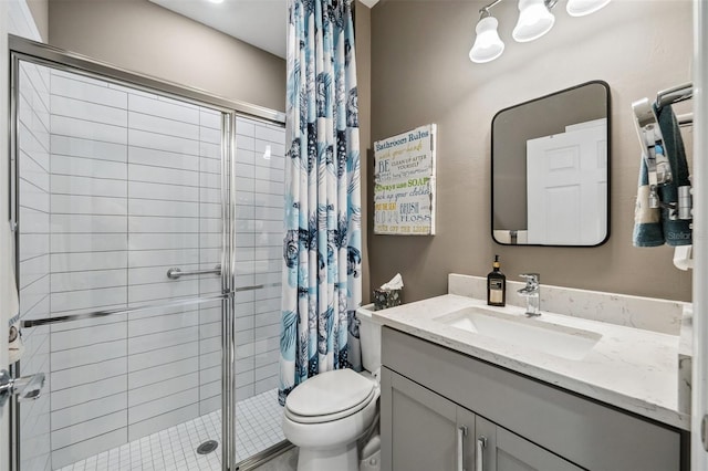 bathroom featuring toilet, a tile shower, and vanity