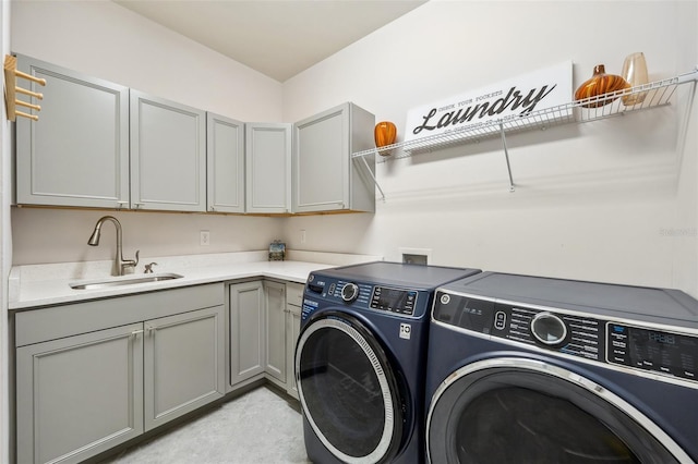 laundry room featuring washing machine and dryer, sink, and cabinets