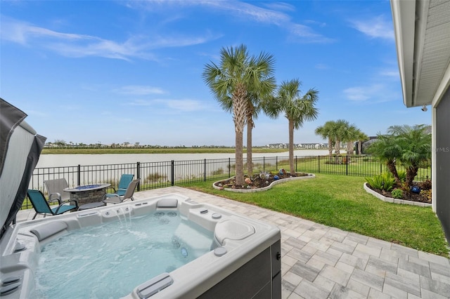 view of swimming pool featuring a hot tub, a fire pit, a yard, and a water view