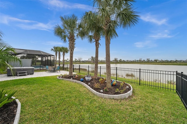 view of yard with a hot tub, a patio area, a lanai, and a water view