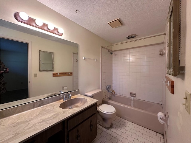 bathroom with toilet, vanity, tile patterned floors, a textured ceiling, and  shower combination