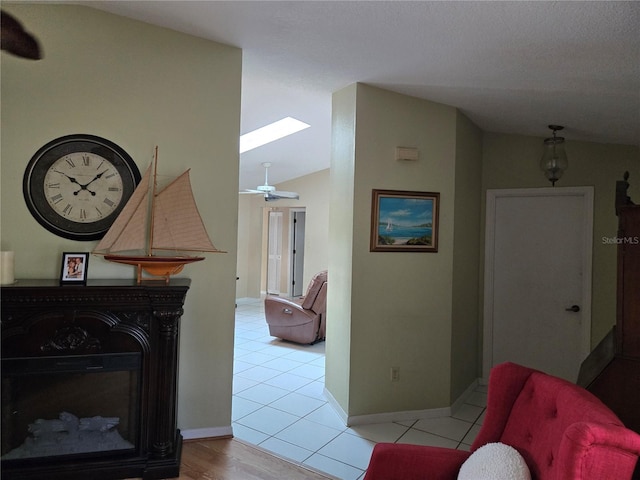 tiled living room with lofted ceiling with skylight