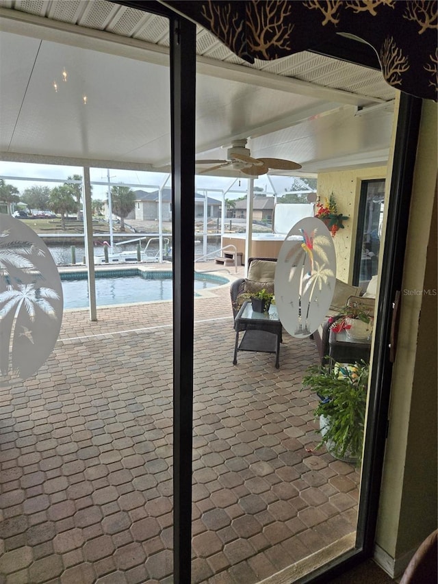 exterior space with a patio area, a water view, and glass enclosure